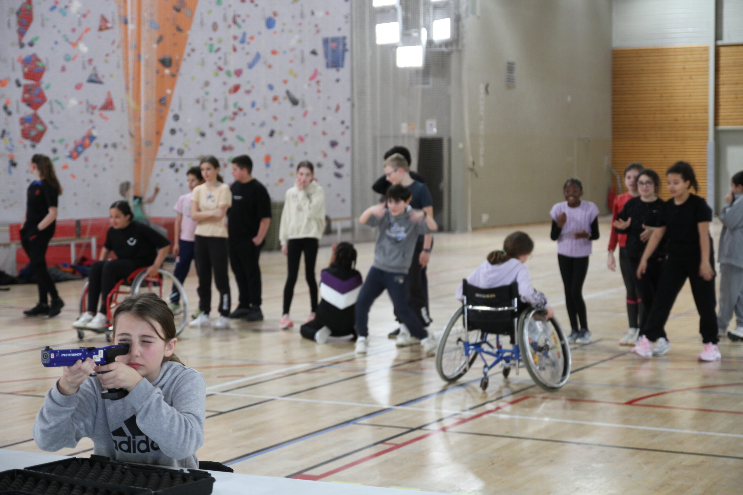 Enfants dans un gymnase faisant une course de fauteuils