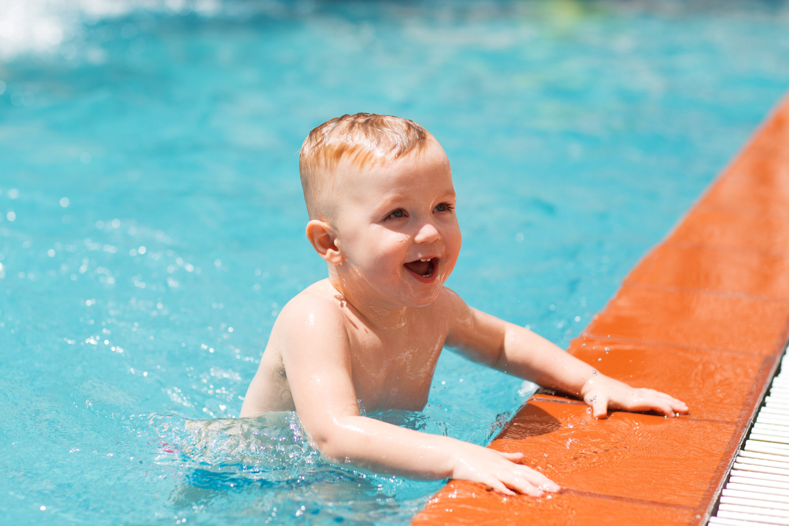 Portrait d'un petit garçon caucasien heureux nageant dans une piscine extérieure et souriant. Concept de vacances d'été, de sport, de santé et d'enfance
