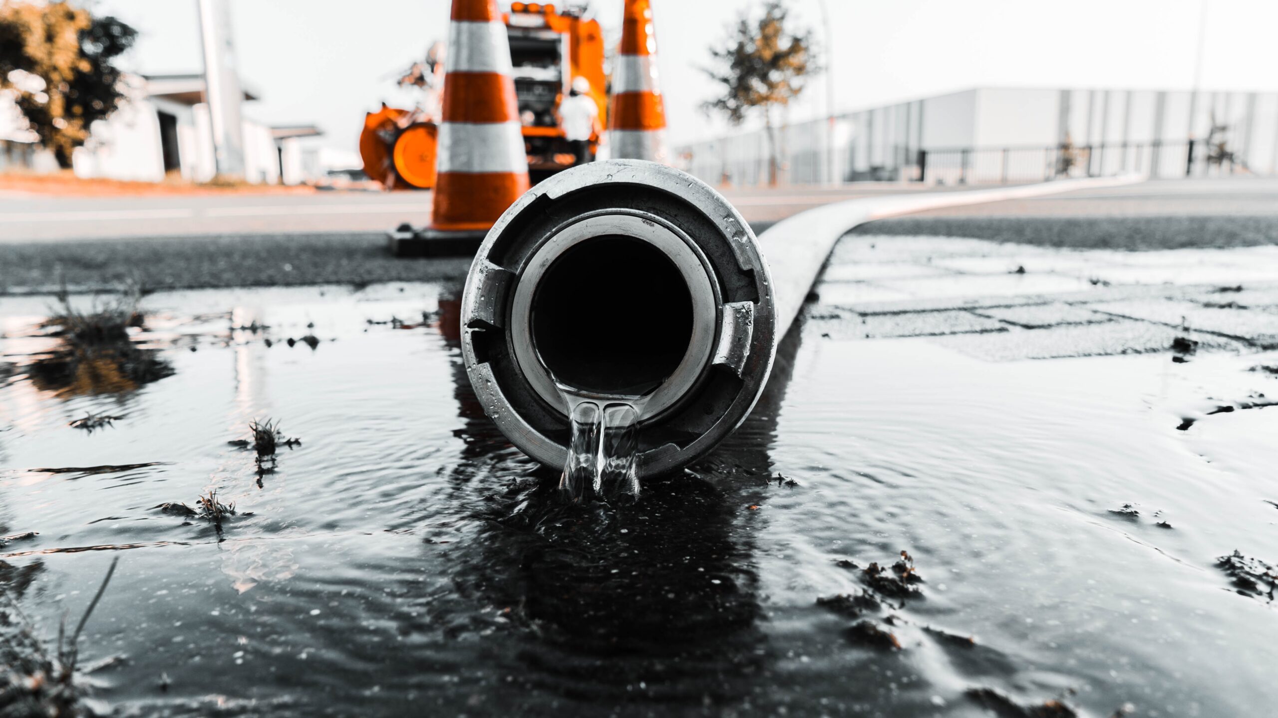 Gros plan sélectif d'un tuyau gris avec de l'eau sortant de son orifice