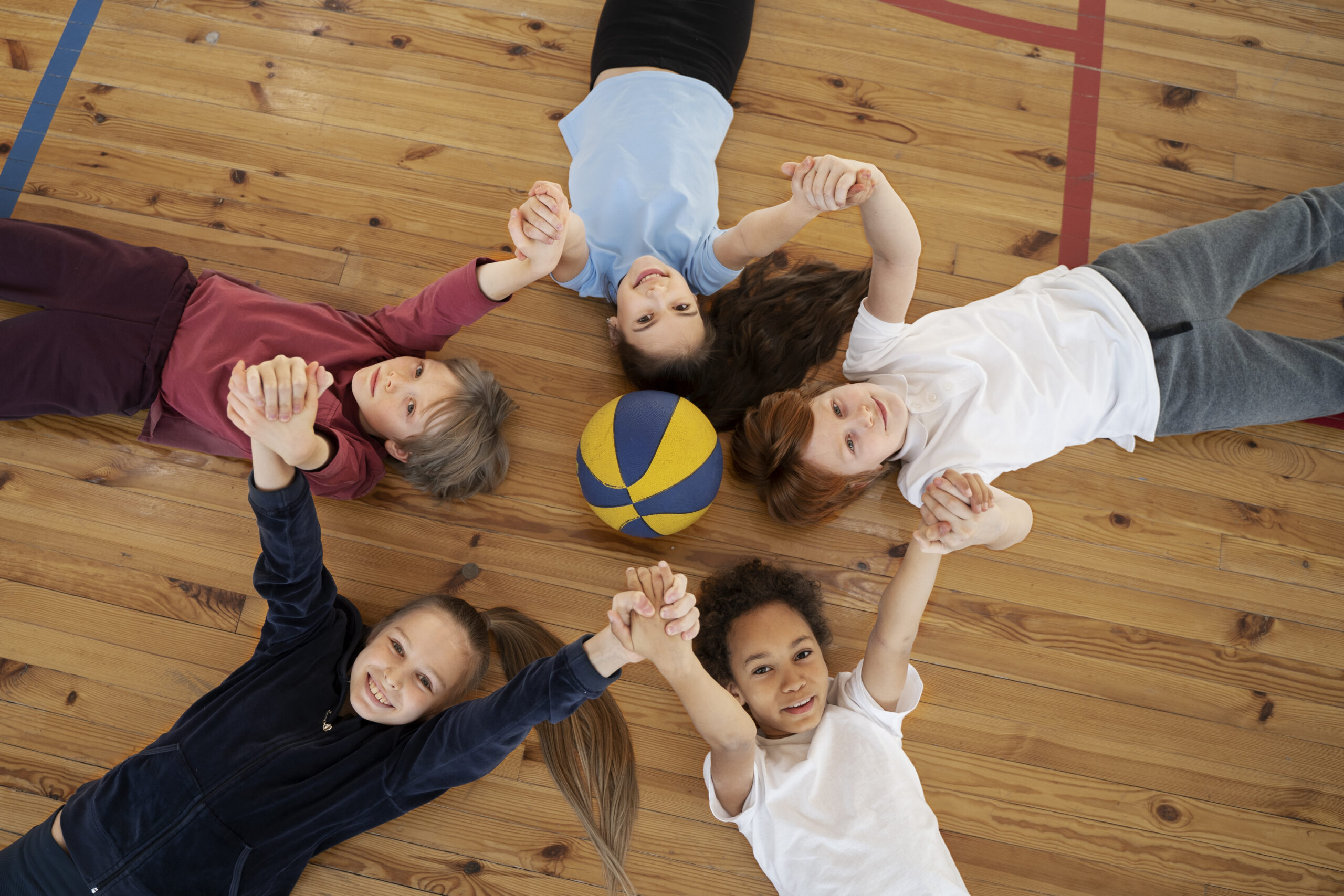 plan-moyen-d-enfants-allonges-sur-le-sol-du-gymnase