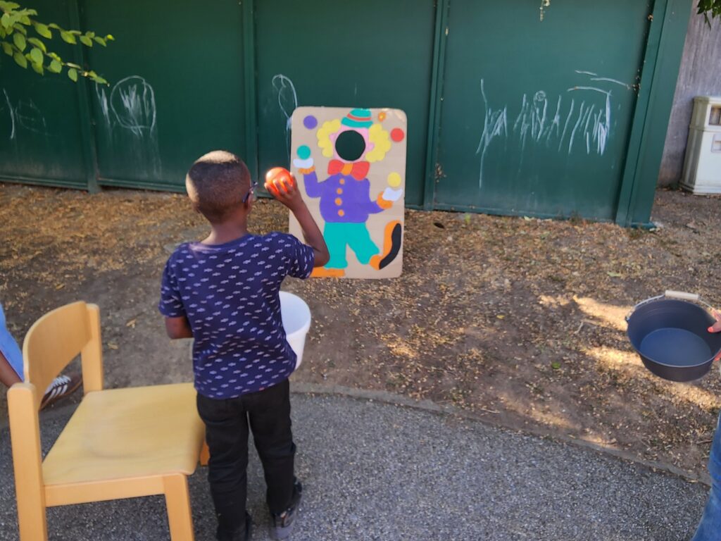 un enfant avec un ballon vise un panier