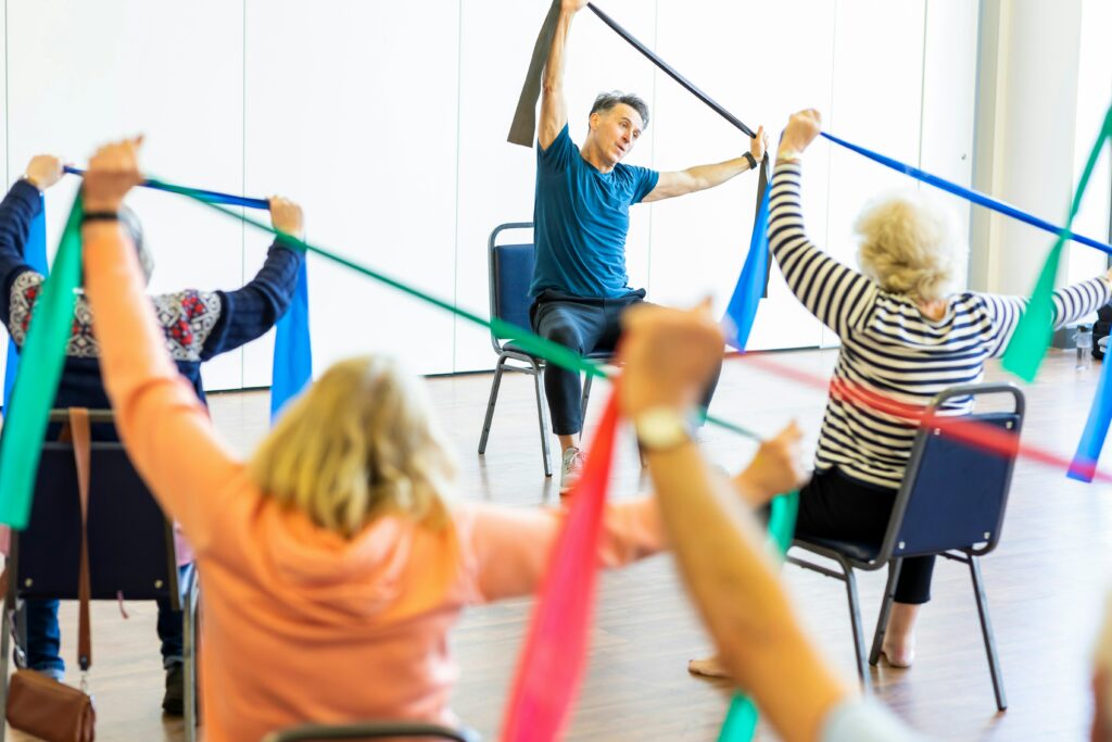 des seniors pratiquent des étirements avec un élastique.